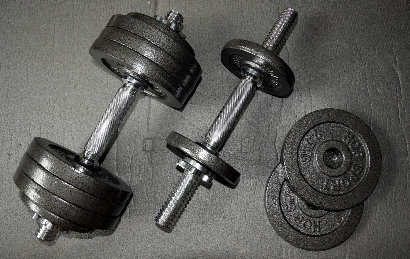 A pair of spin-lock adjustable dumbbells with cast-iron plates and threaded collars.