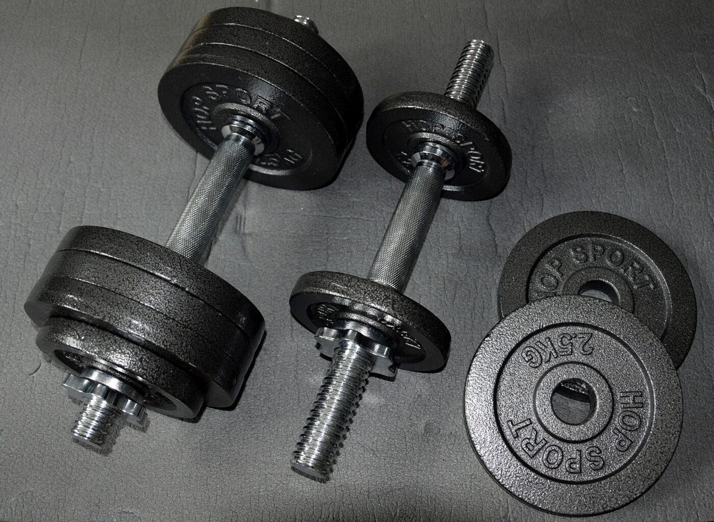 A pair of adjustable dumbbells assembled with round weight plates.