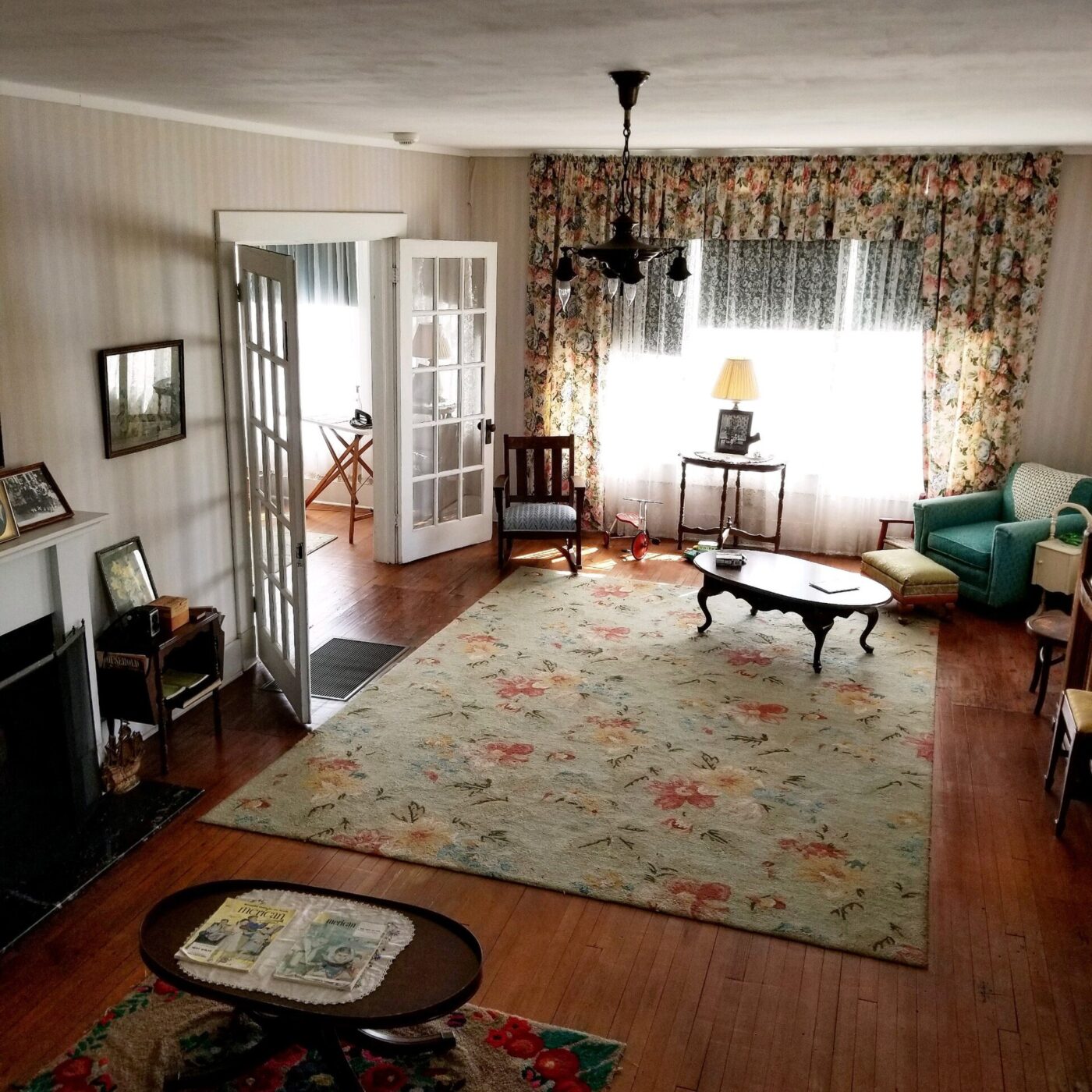 A floral area rug on a hardwood floor in a furnished living room.