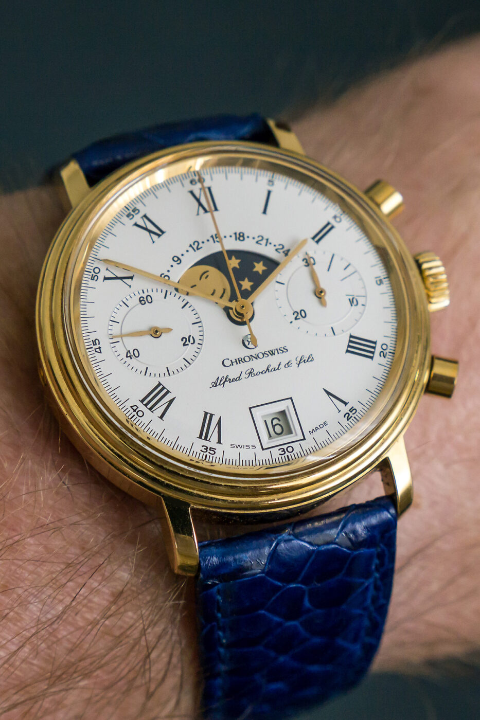 Close-up, well-lit photo of a Chronoswiss mechanical chronograph dial and crown on a wrist.