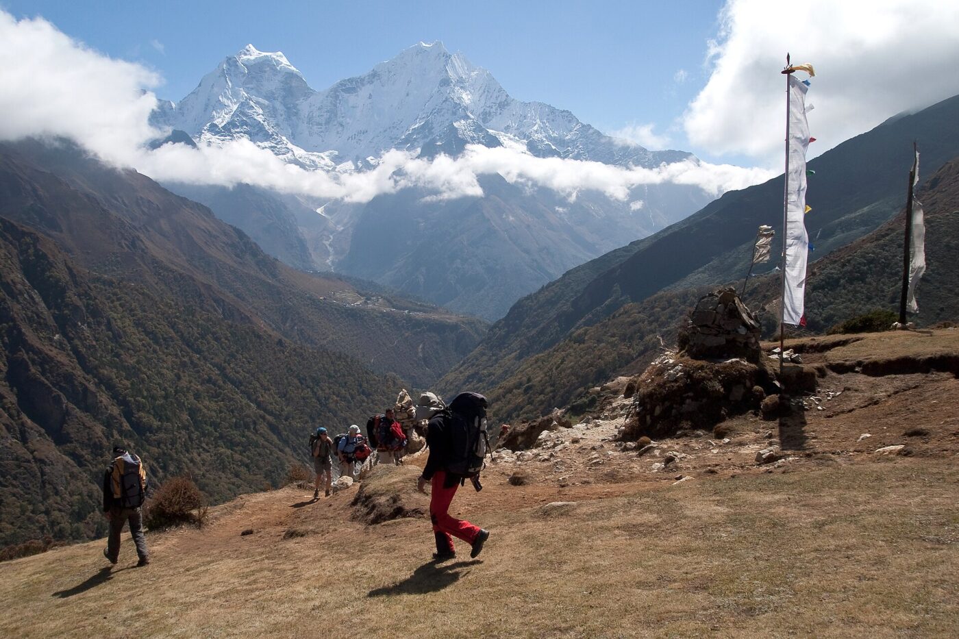 Trekkers carrying packs on a mountain trail.