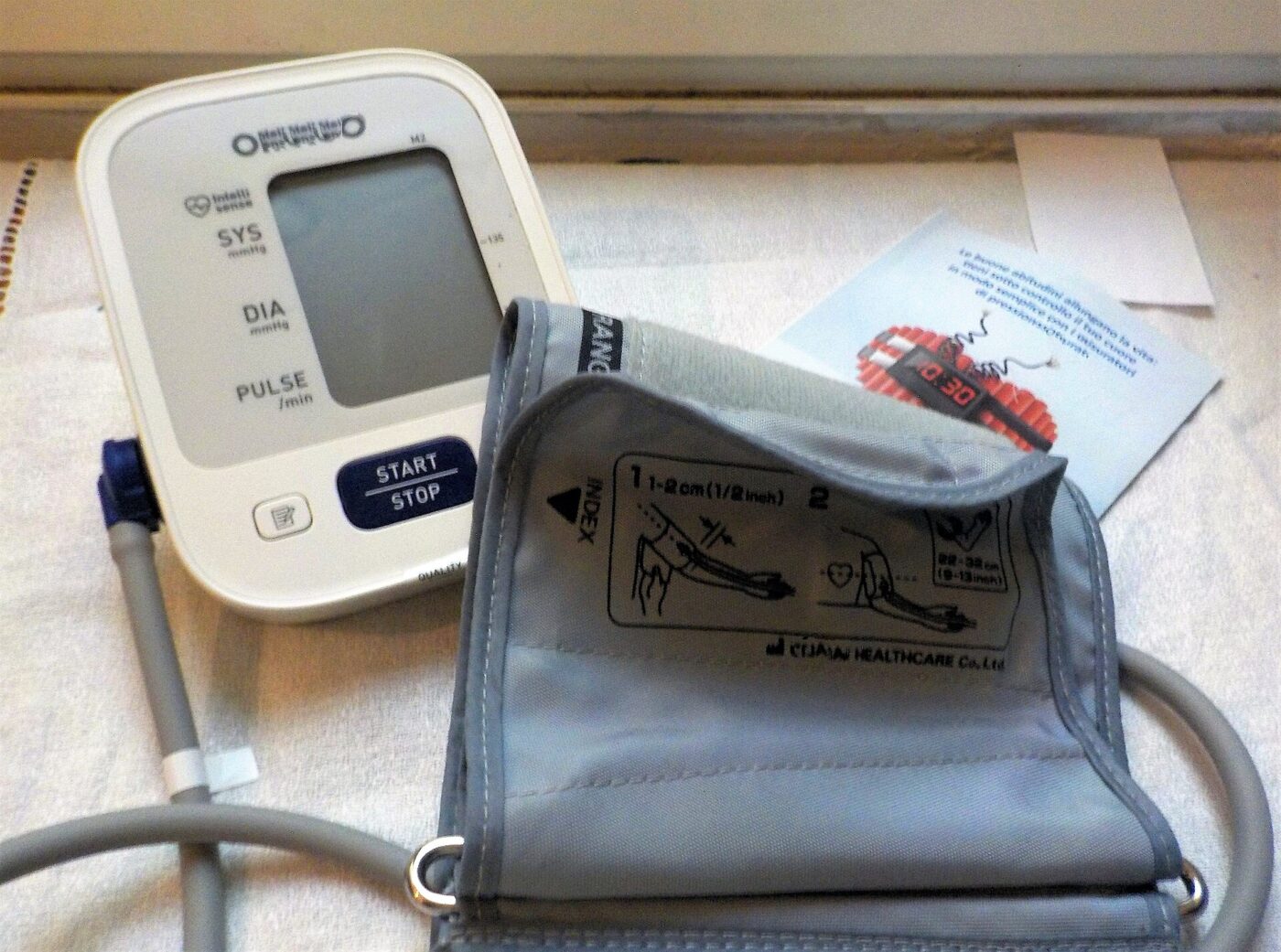 An automatic oscillometric blood pressure monitor with its cuff.