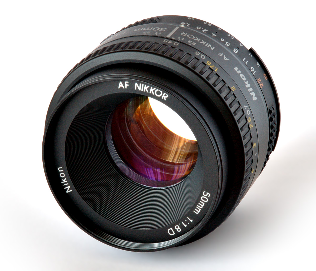 A Nikkor 50mm camera lens, its glass elements clearly visible.