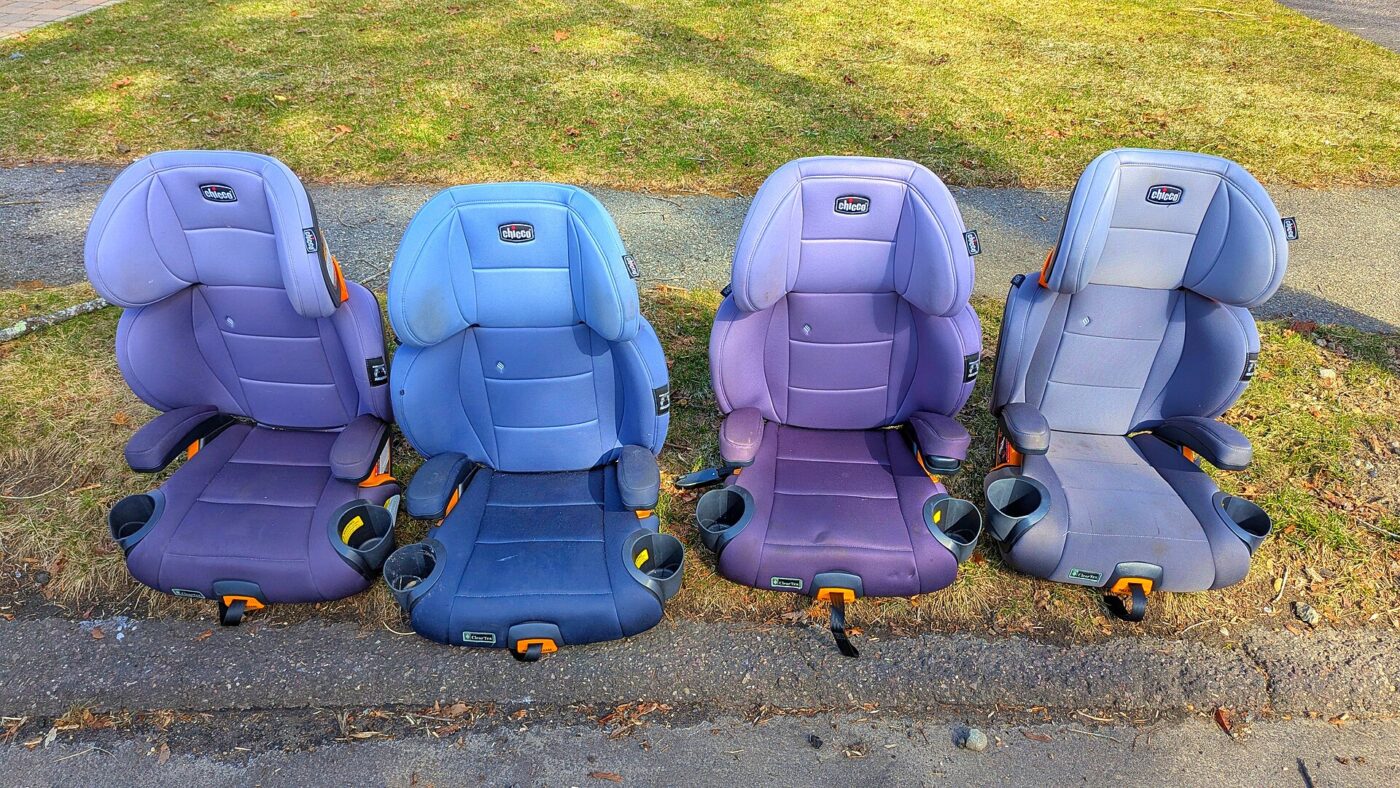Booster seats lined up on a lawn.