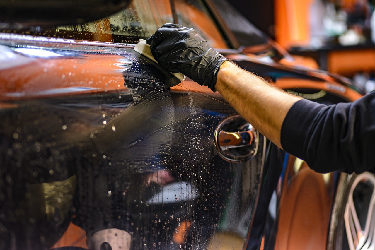 A detailer polishing a car's paint.