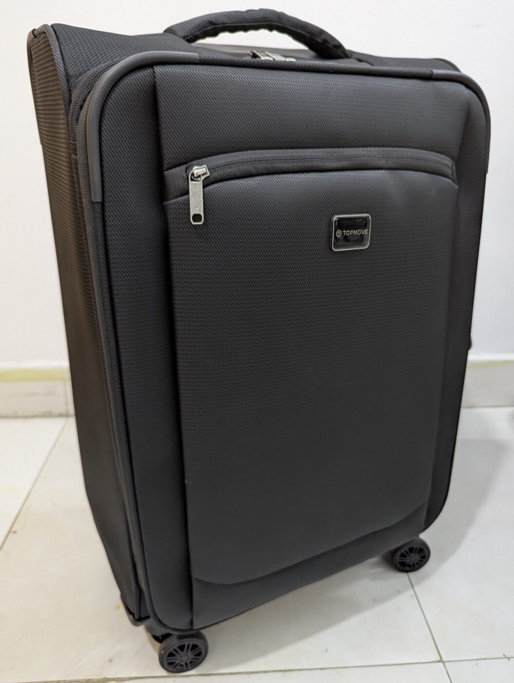 A black soft-sided carry-on suitcase standing upright on its wheels.