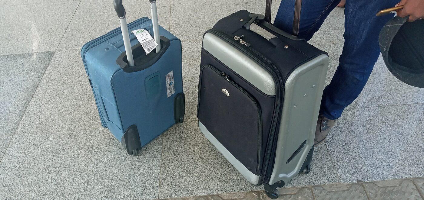 Two carry-on suitcases at an airport.