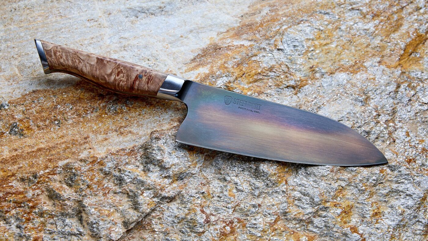 A 6-inch chef's knife in carbon steel. Harder steel holds an edge longer but forgives less twisting and bone.
