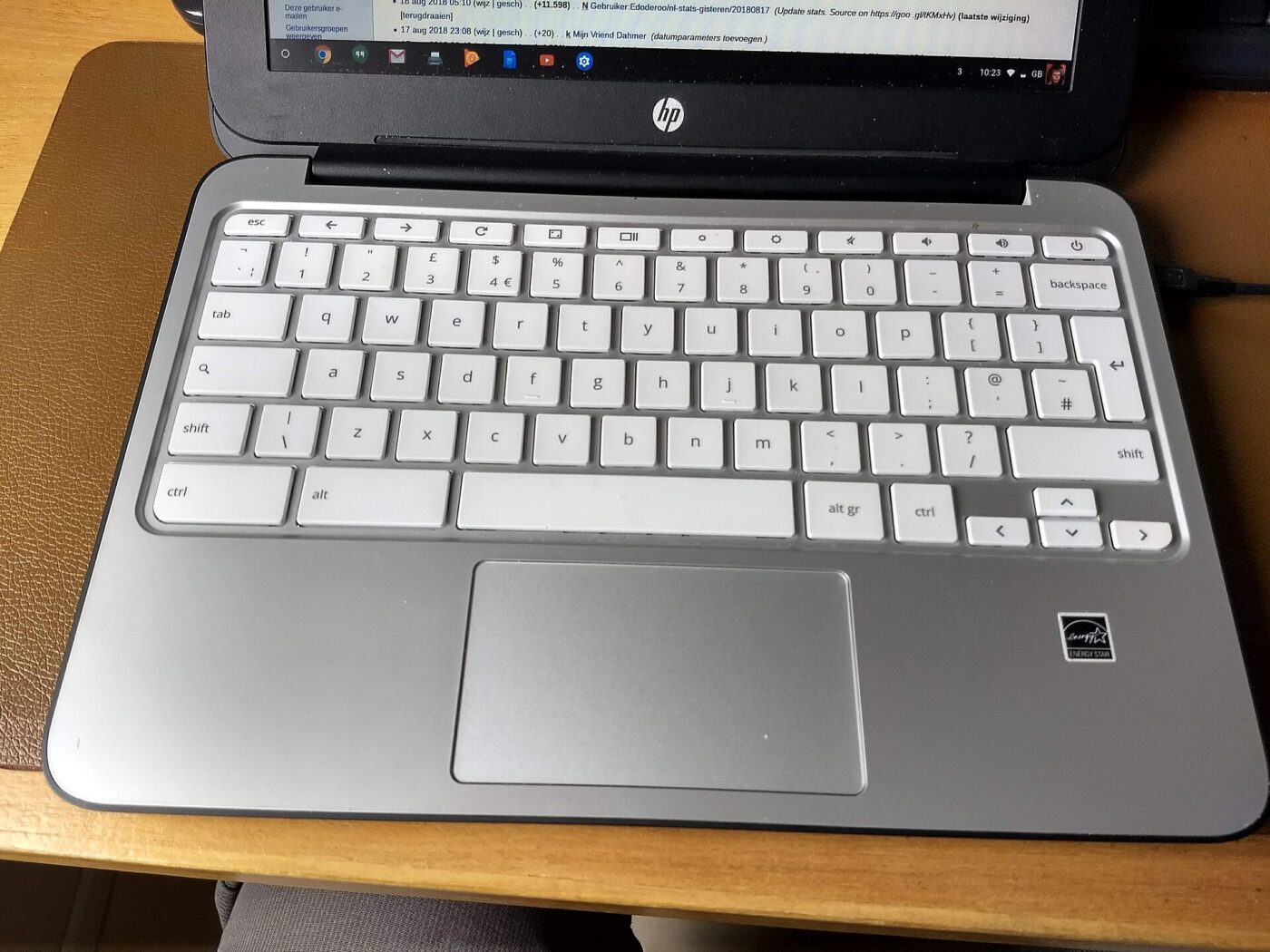An open silver Chromebook laptop sitting on a table.
