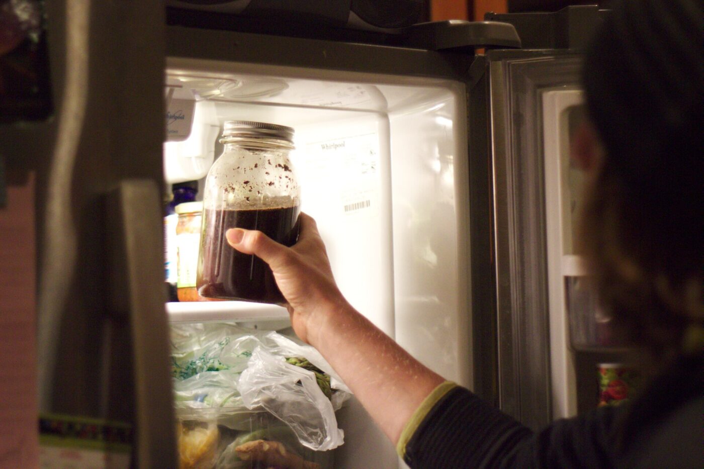 Taking a jar of cold brew out of the fridge.