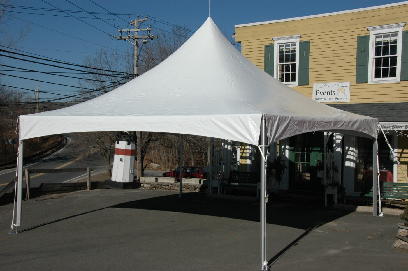 White high-peak frame canopy tent set up empty with no weights visible.