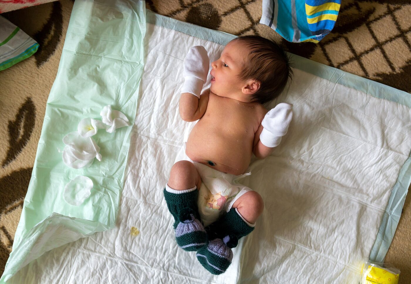 A newborn lying on a changing mat.