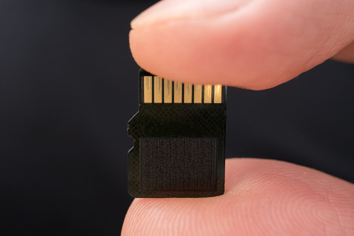 A microSD card held between two fingers, showing its small size.