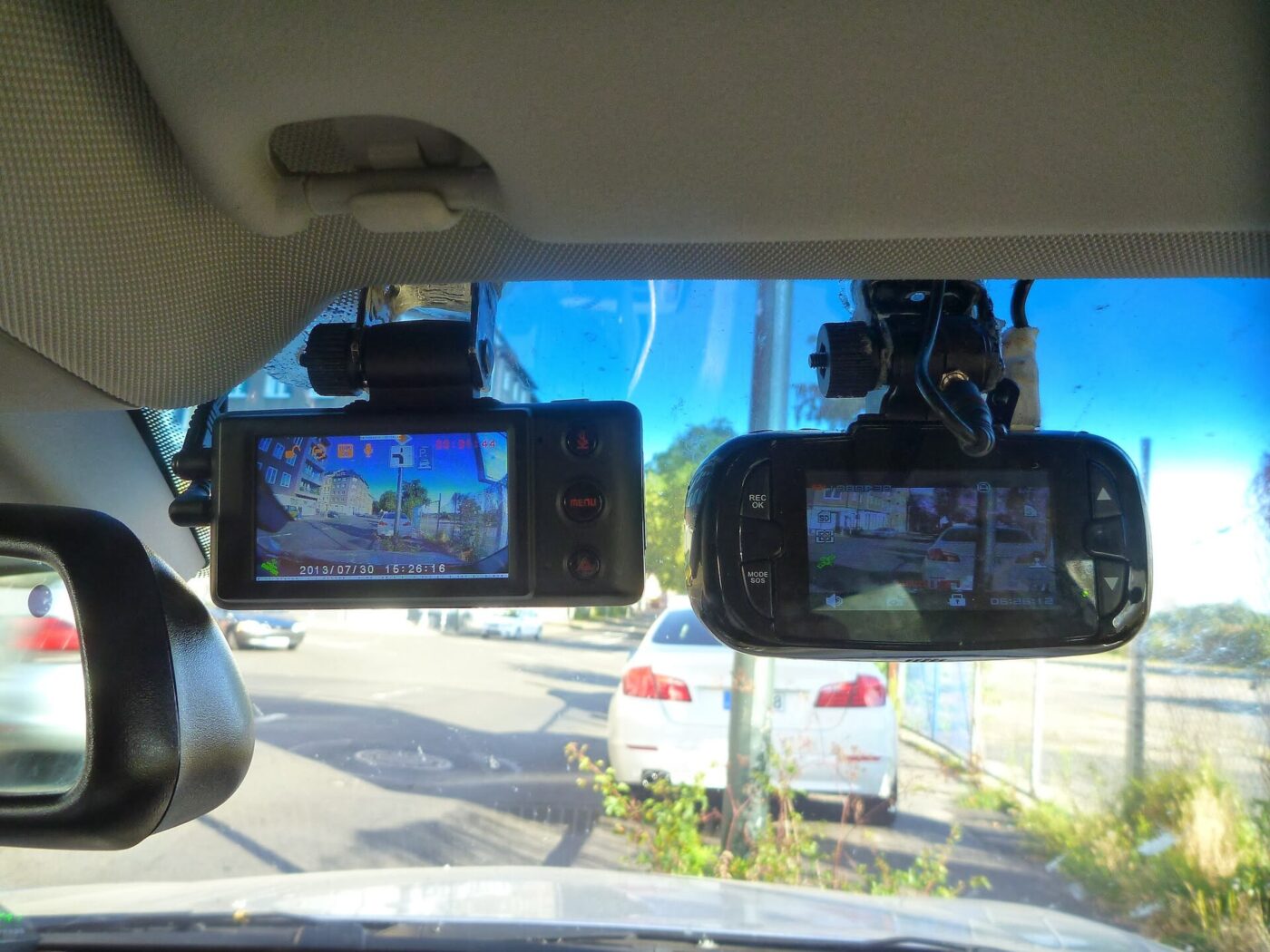 Two dashcams mounted on a windscreen.