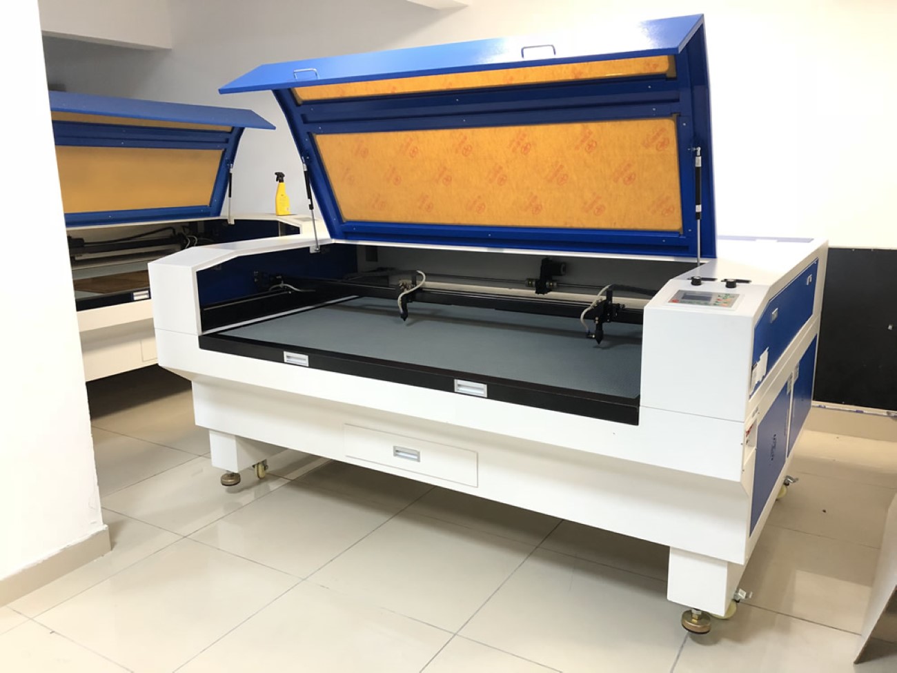 White enclosed laser engraving machine with the top cover lifted open.