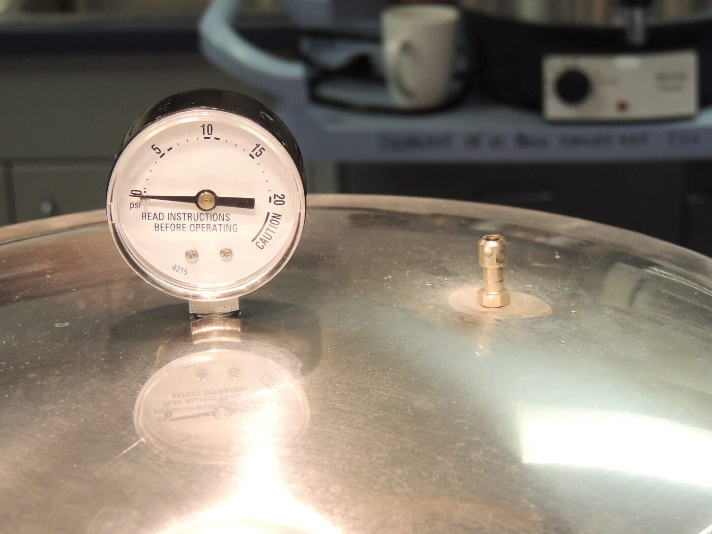 Round dial gauge on the lid of a stovetop pressure canner.