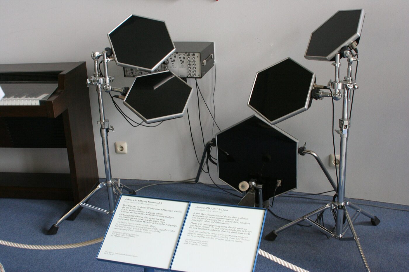 An electronic drum kit set up on a rug in a carpeted home practice space.