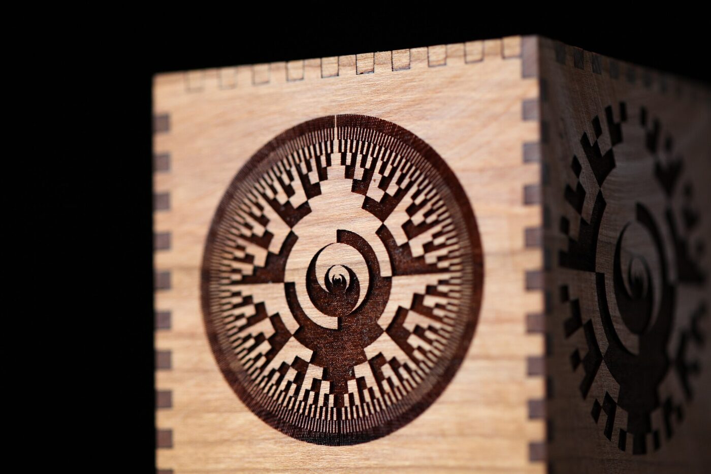 A cherry wood box laser-engraved with a pattern.