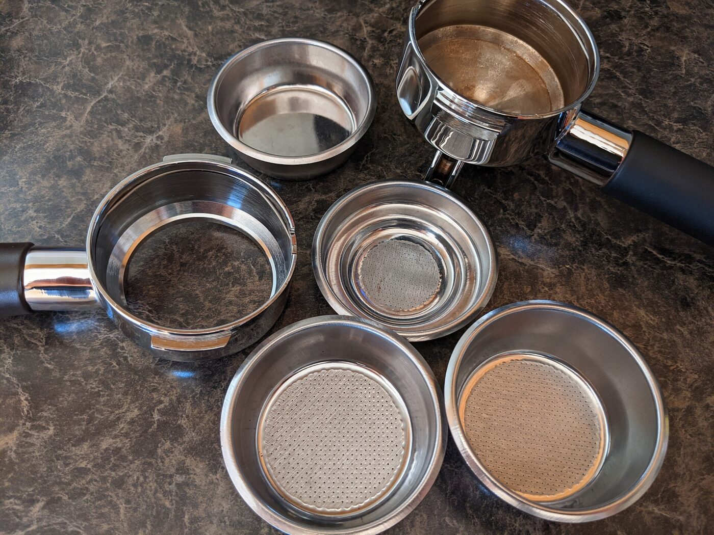 Portafilters and filter baskets of different types.
