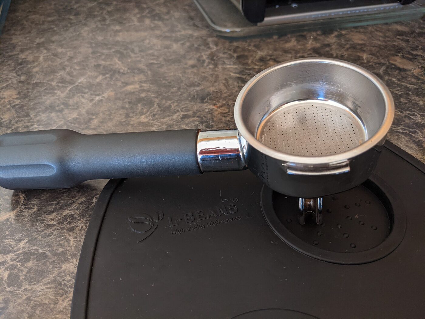 A portafilter resting on a tamping mat.