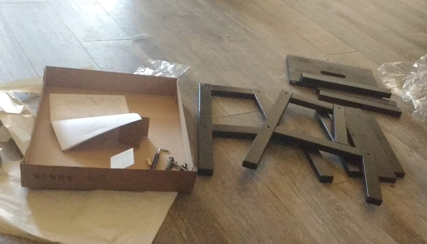 Flat-pack furniture parts and hardware laid out for assembly.