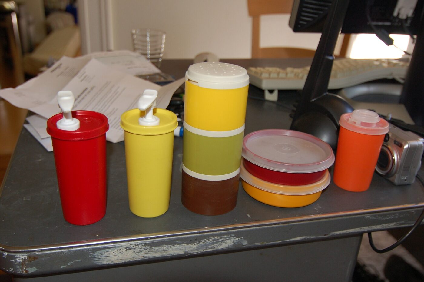 Vintage Tupperware containers on a cluttered desk.