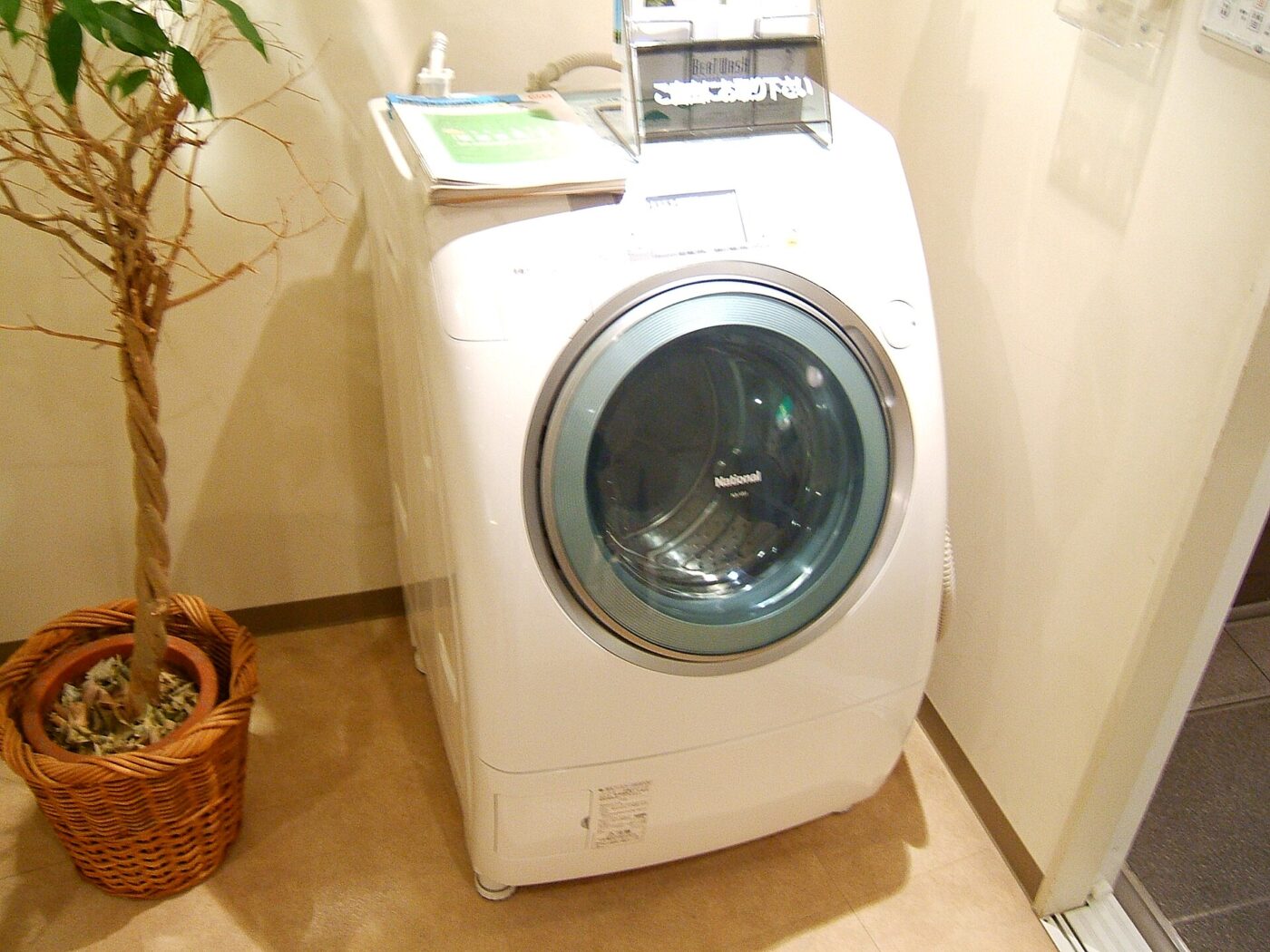 A compact front-loading washing machine in a home.