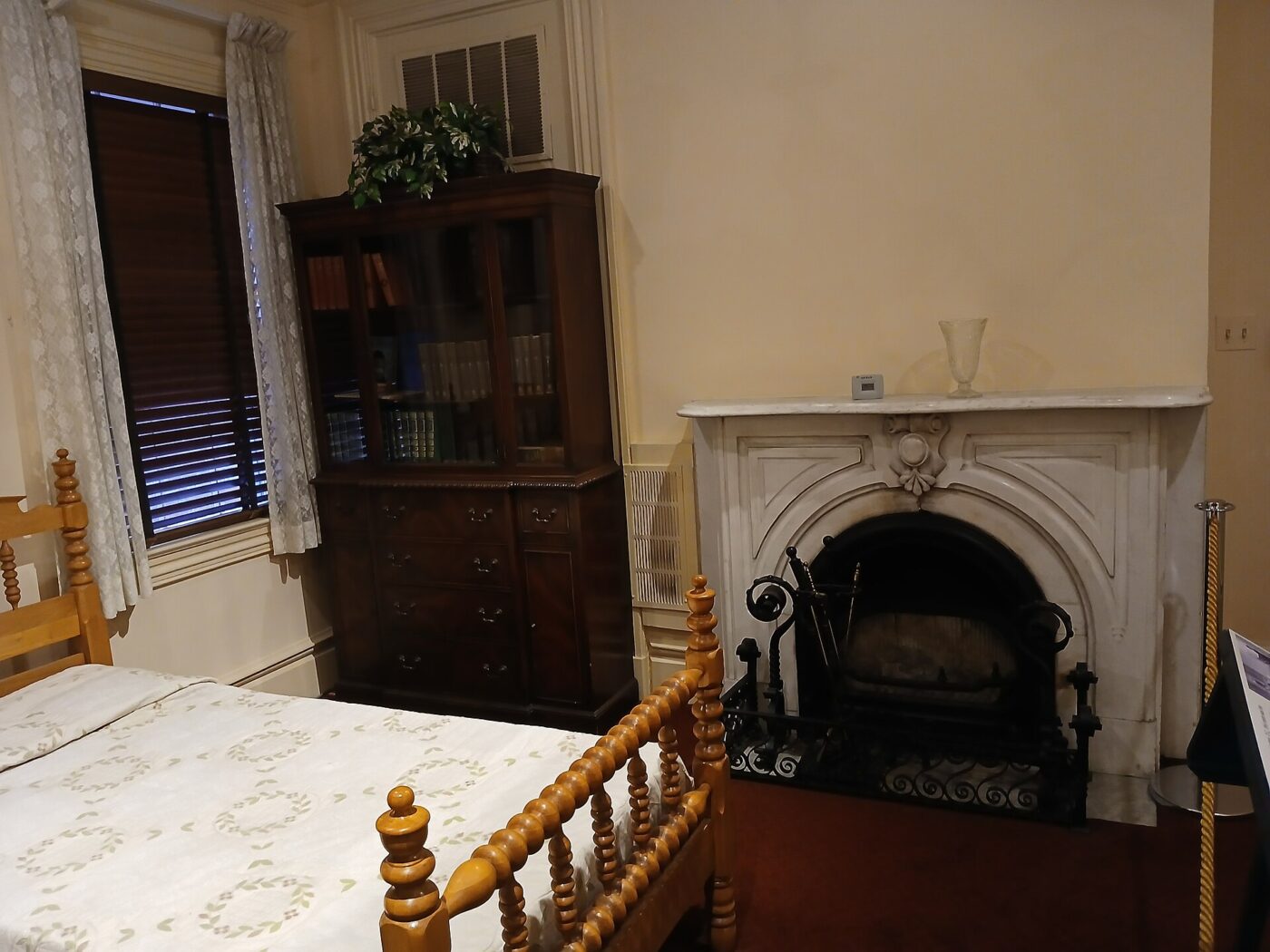 A dresser beside a fireplace.