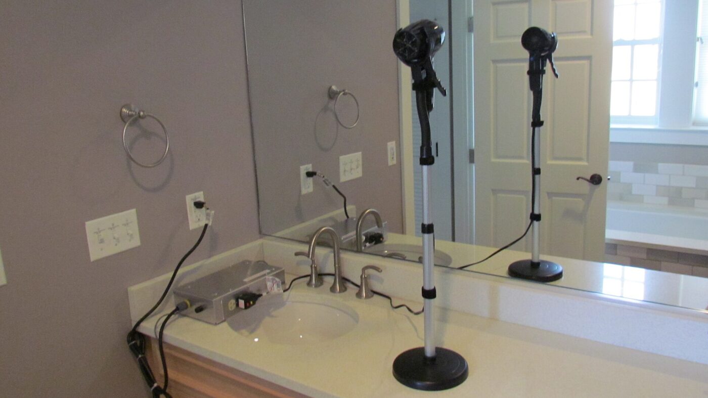 A wall-mounted hair dryer in a hotel bathroom.