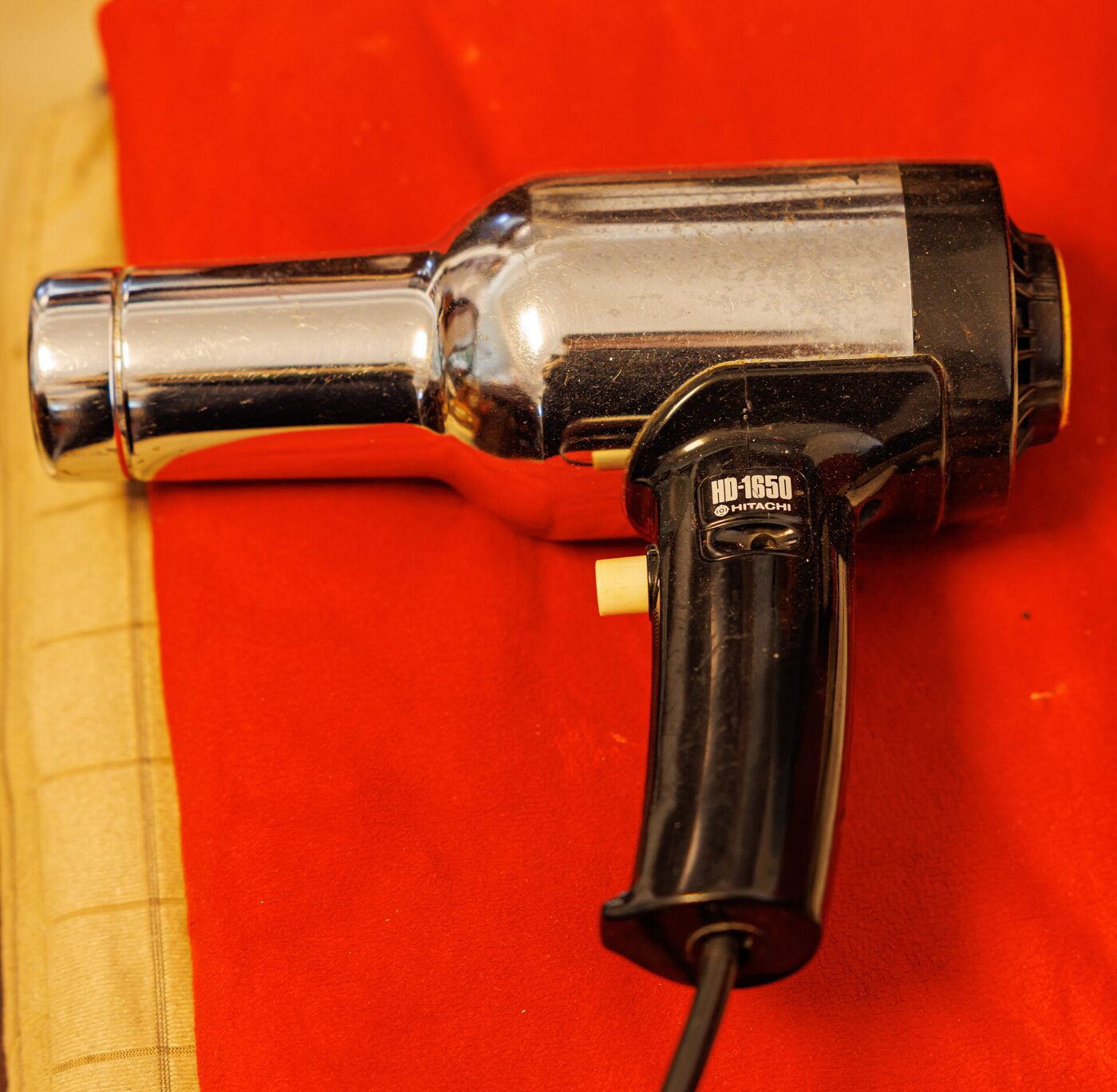 A handheld hair dryer photographed on a plain background.