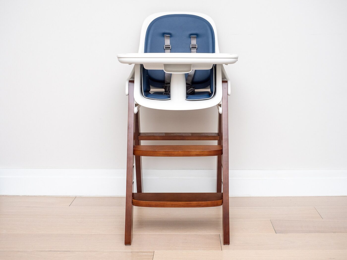 A baby high chair with a removable tray.