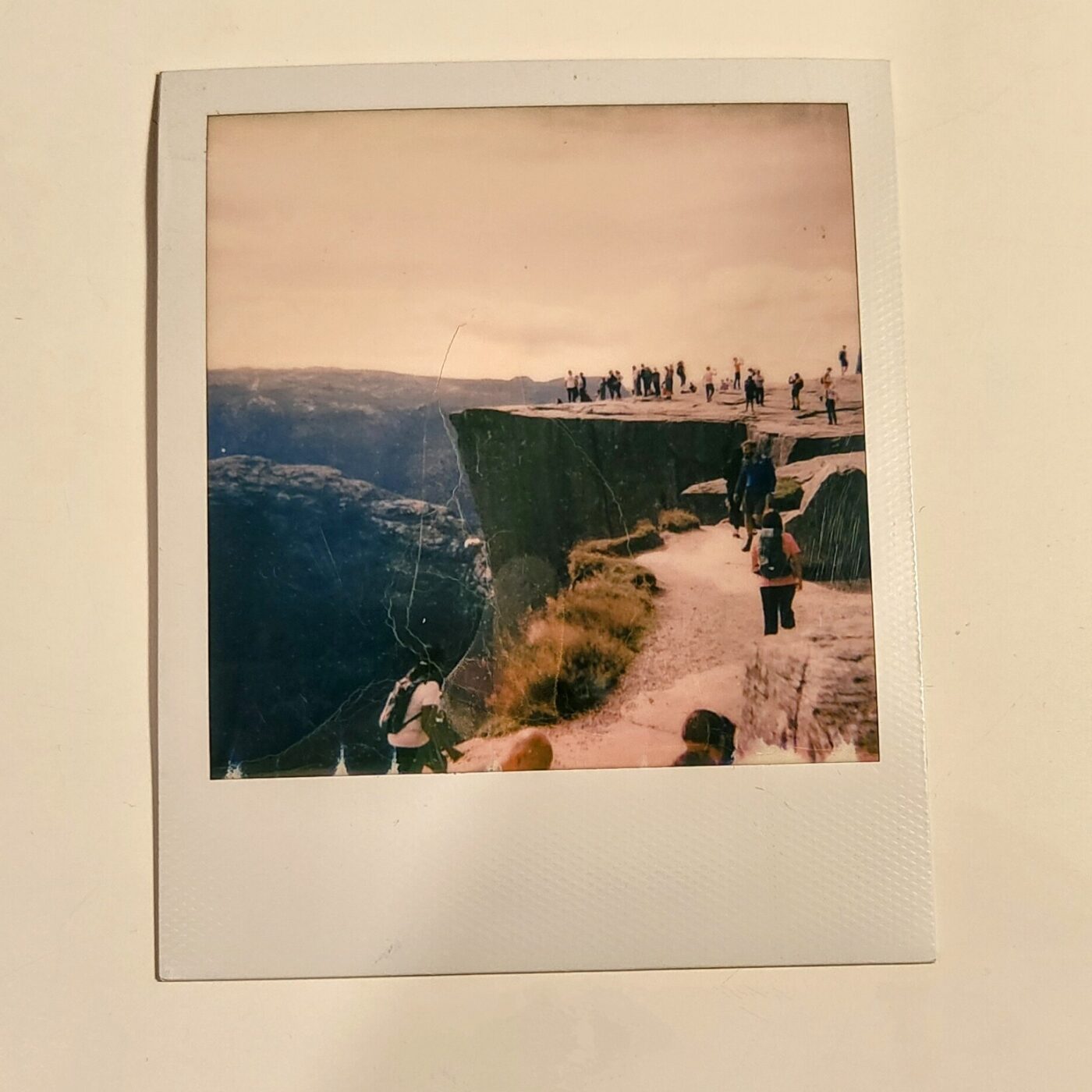 A square instant photo print with a white border, showing a landscape.