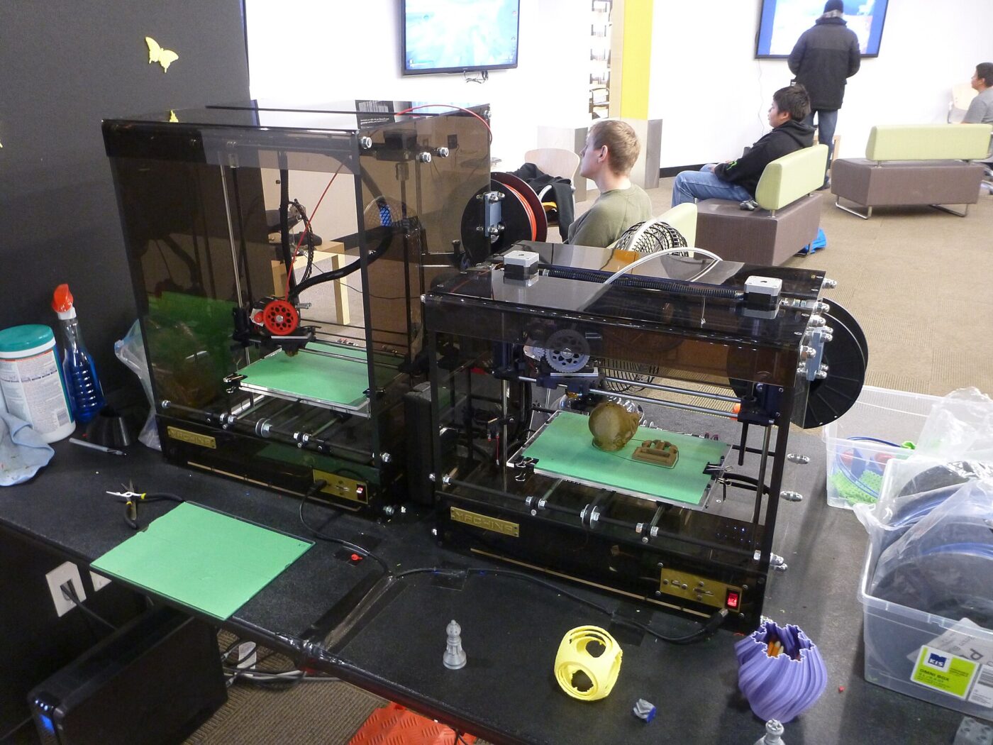 A 3D printer extruding melted plastic filament to print an object on its build plate.