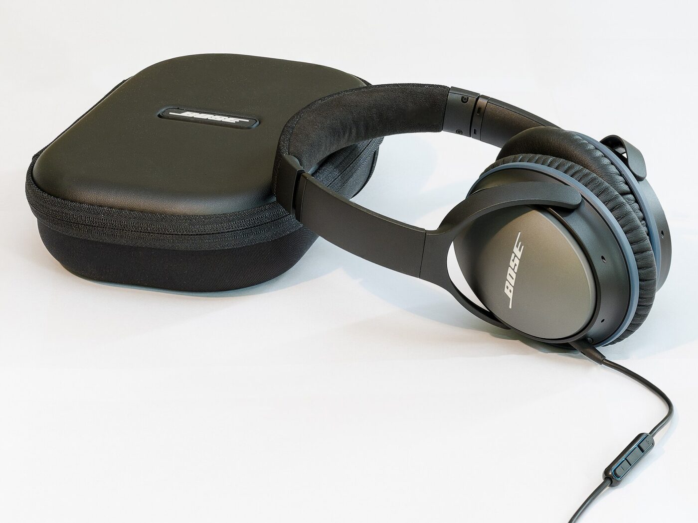 A pair of noise-cancelling headphones resting on their padded carrying case.