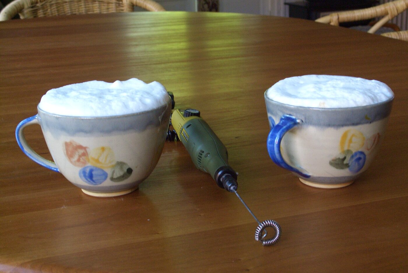 Frothing milk for cappuccinos with a handheld frother.