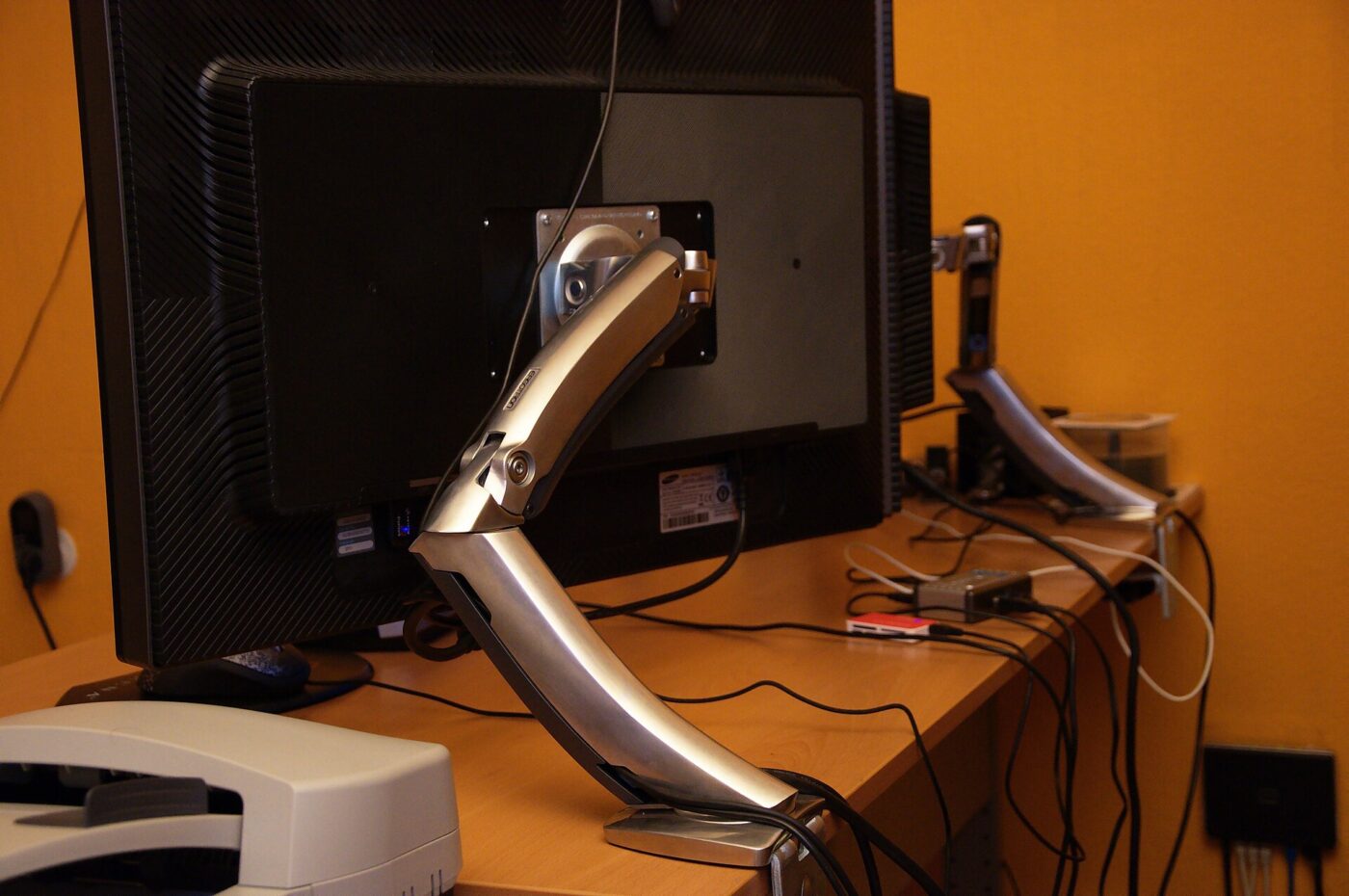 A monitor mounted on an articulated desk arm.