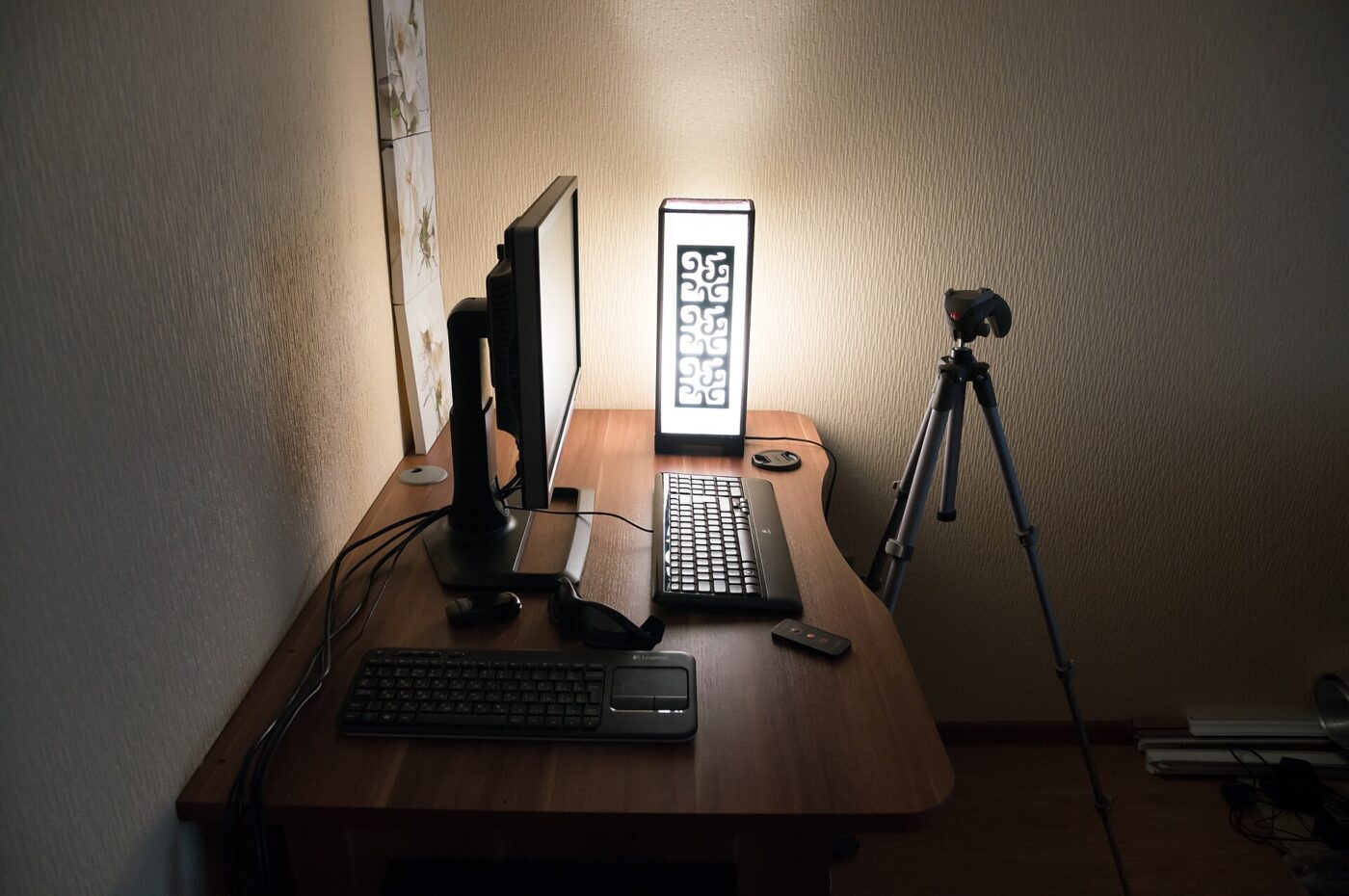 A desk setup in a dim room, the kind of lighting where panel contrast matters most.