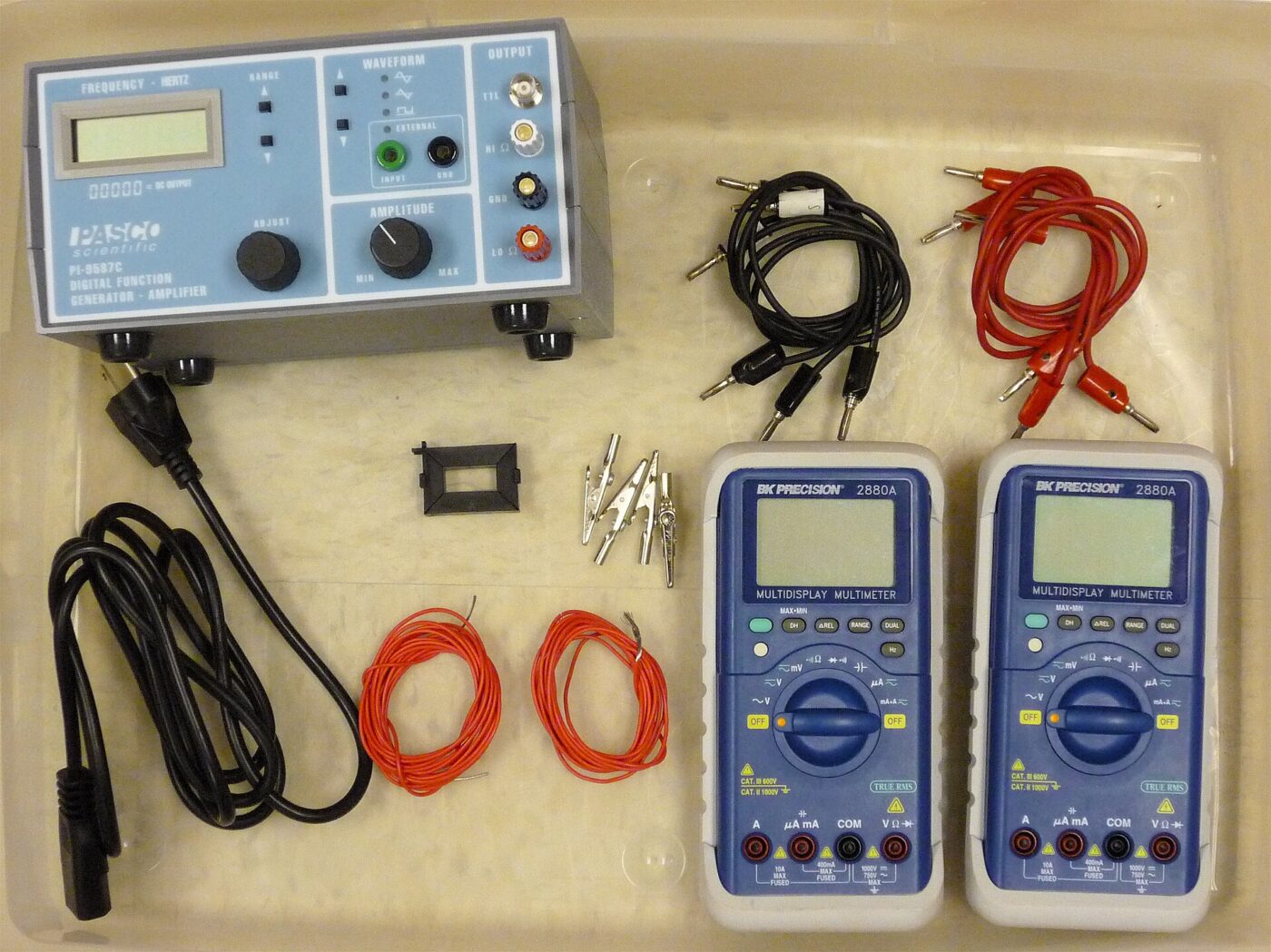 Two handheld multimeters with test leads and a transformer kit.