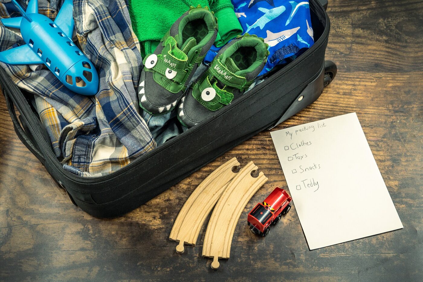 A child's holiday packing list next to a neatly packed suitcase.