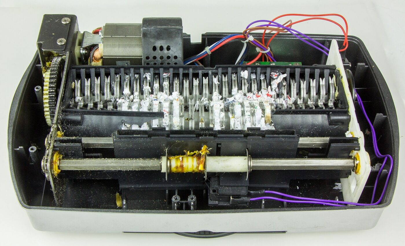 Inside a paper shredder: the motor and gear train that overheat when pushed past the duty cycle.