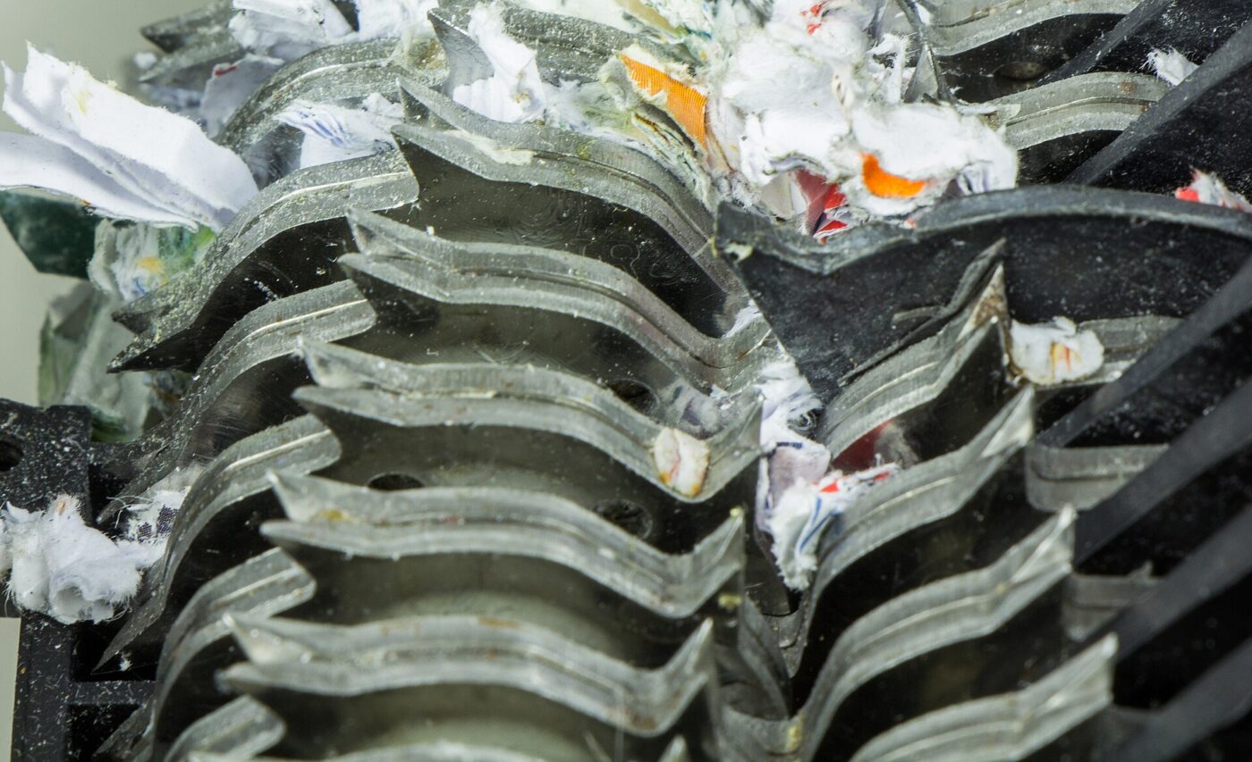 Paper jammed between the cutting blades of a shredder.