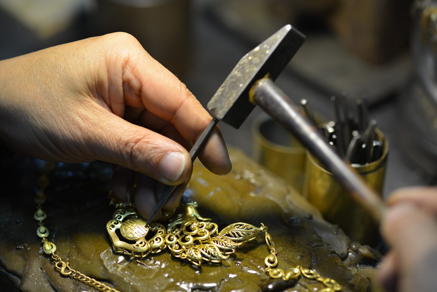 A jeweller working on a handmade gold necklace.