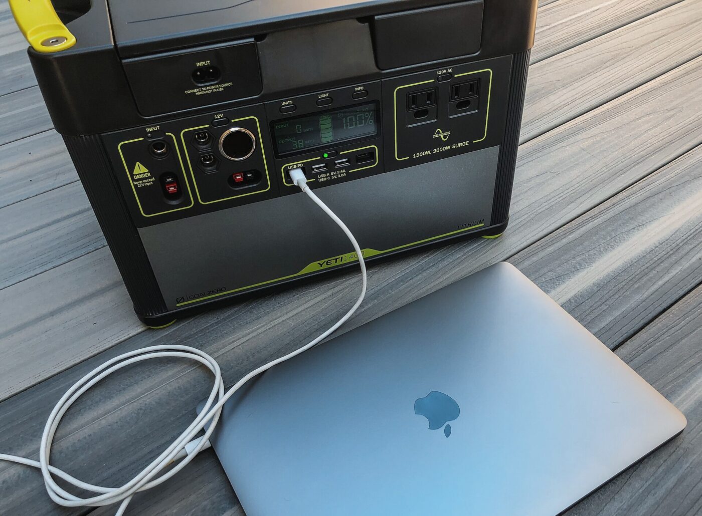 A portable power station charging a laptop.