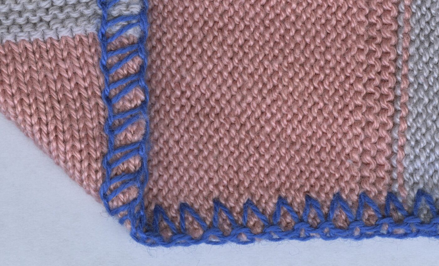 Close-up of a pink knit fabric edge finished with a blue three-thread overlock stitch.