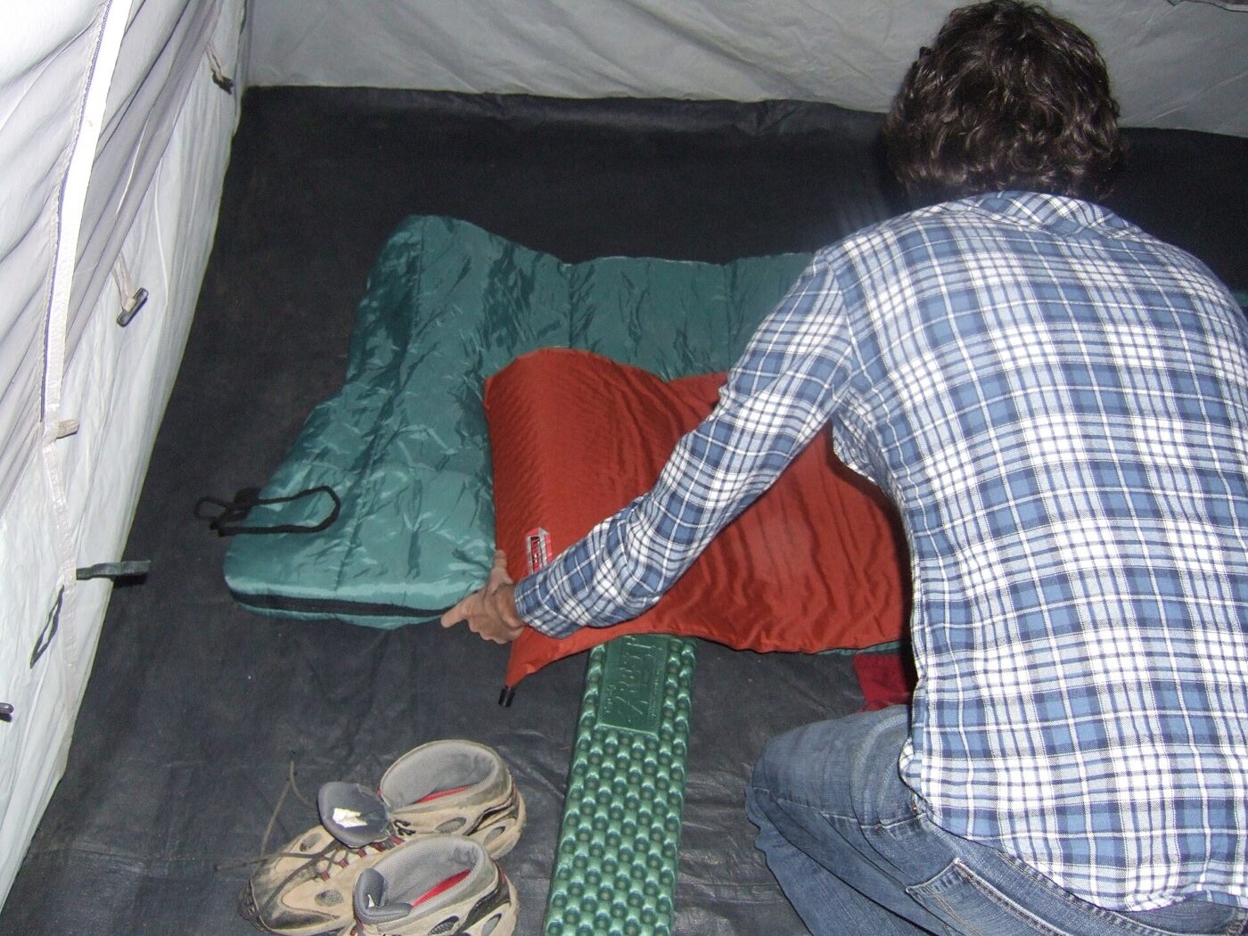 Laying out a sleeping pad and sleeping bag inside a tent.