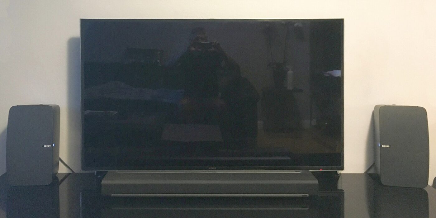 A Samsung TV flanked by Sonos wireless speakers, with a soundbar underneath.