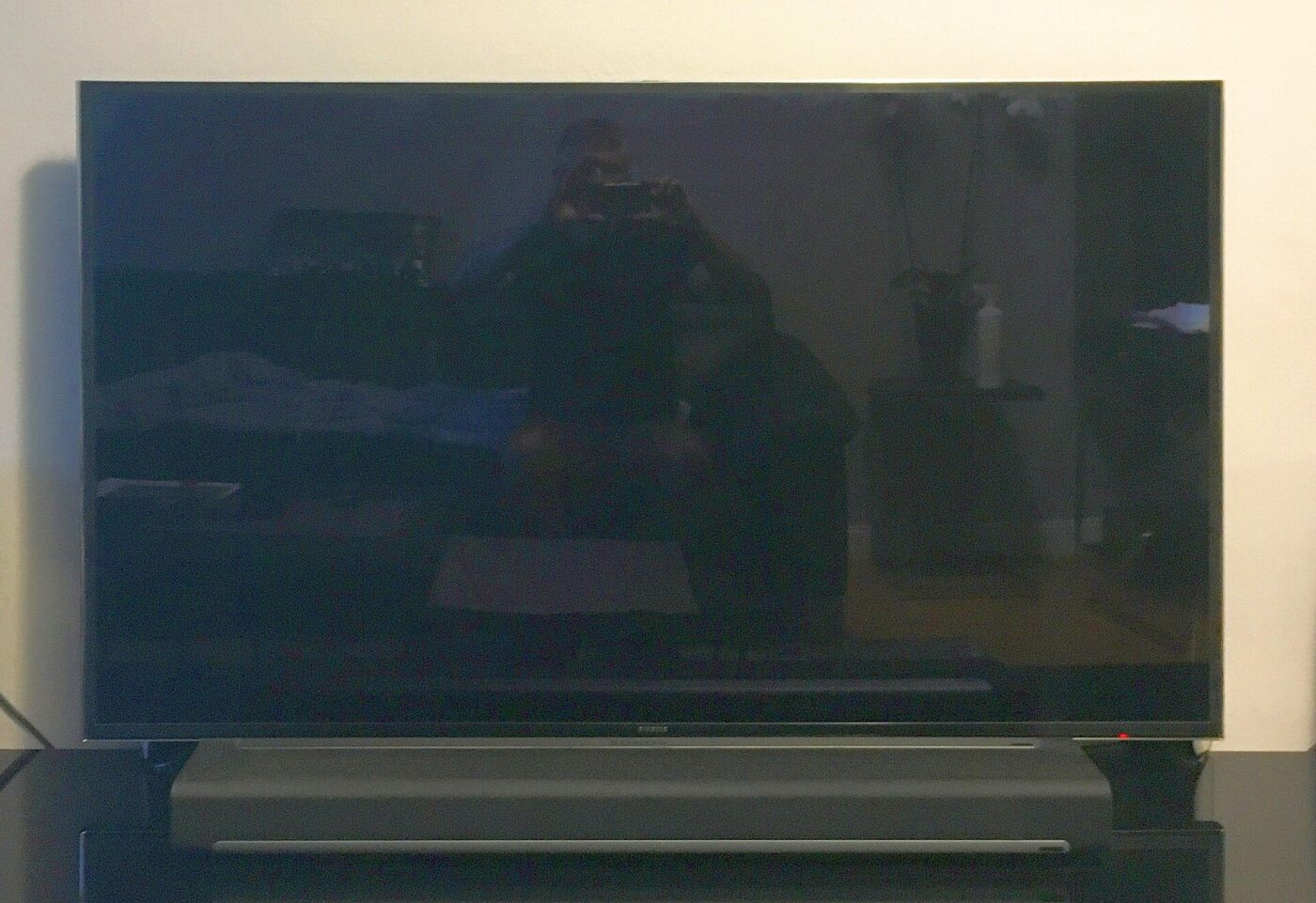 A flat-screen TV with a soundbar placed on the console below it.