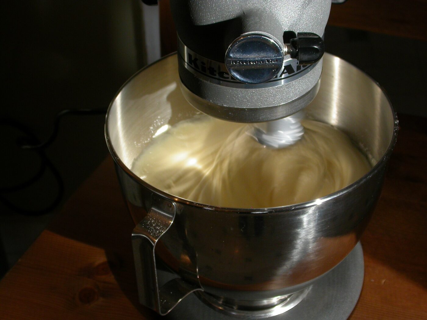 A stand mixer bowl in the middle of a mix.