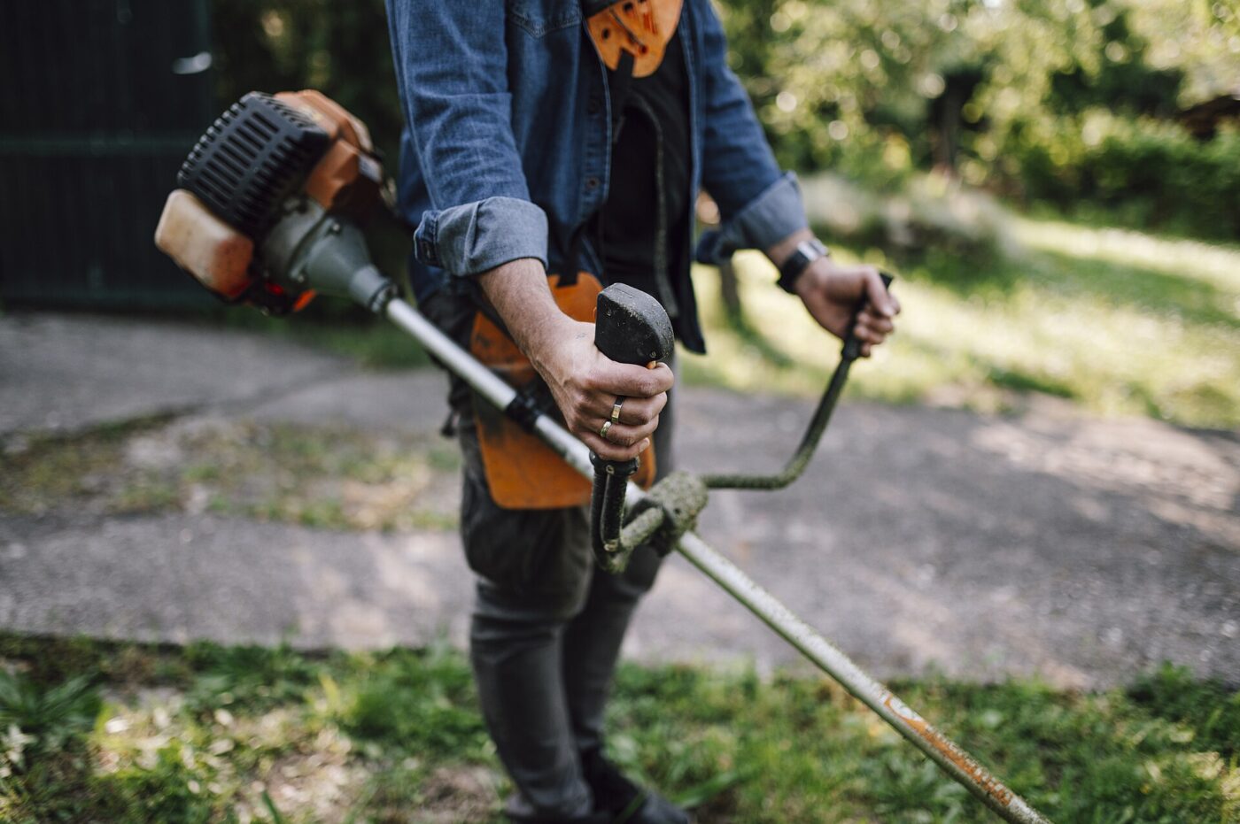 Cutting grass with a string trimmer.