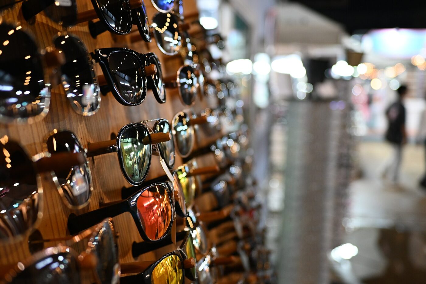 Sunglasses display rack with multiple lenses in different mirrored and tinted colors, seen up close.